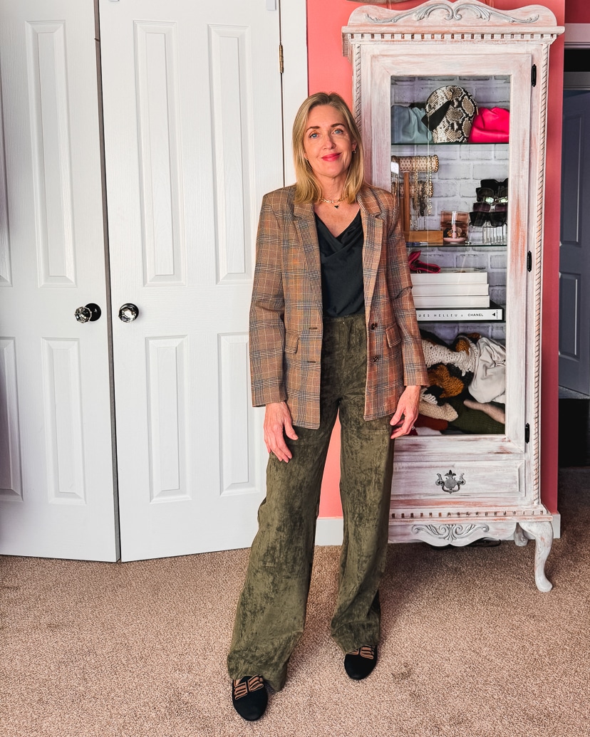 green suede pants outfit with a black top and plaid blazer.