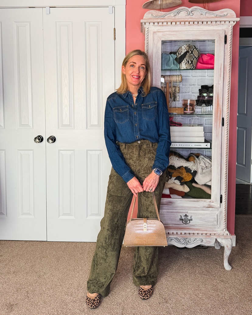 woman wearing olive green pants and a denim button-up shirt.