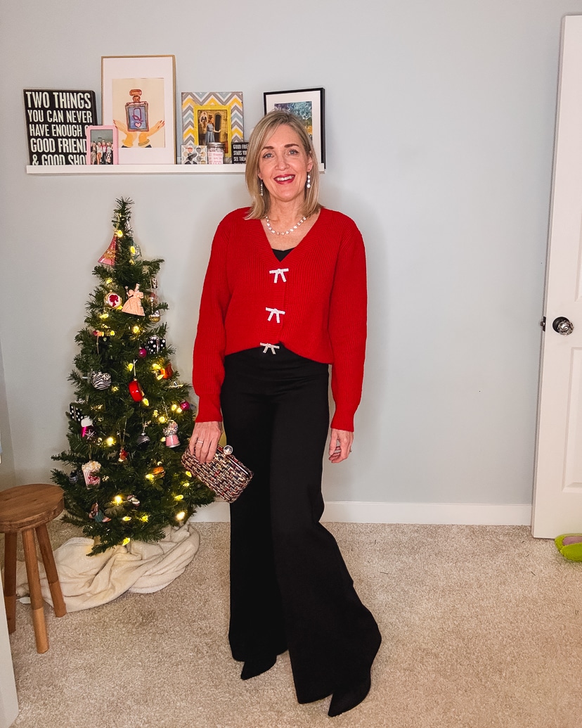 holiday outfit for any occasion. Red cardigan with rhinestone bows, black ponte pants, boots, tweed clutch